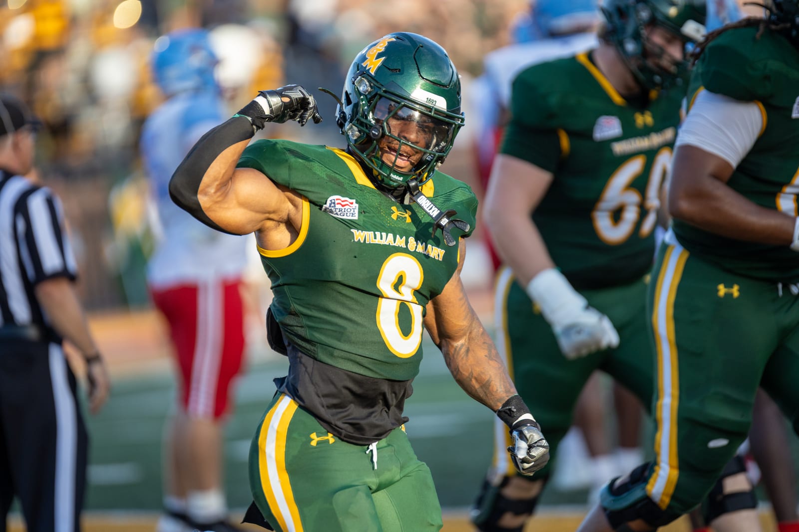 William & Mary running back Andrew King flexes in celebration in golden evening light