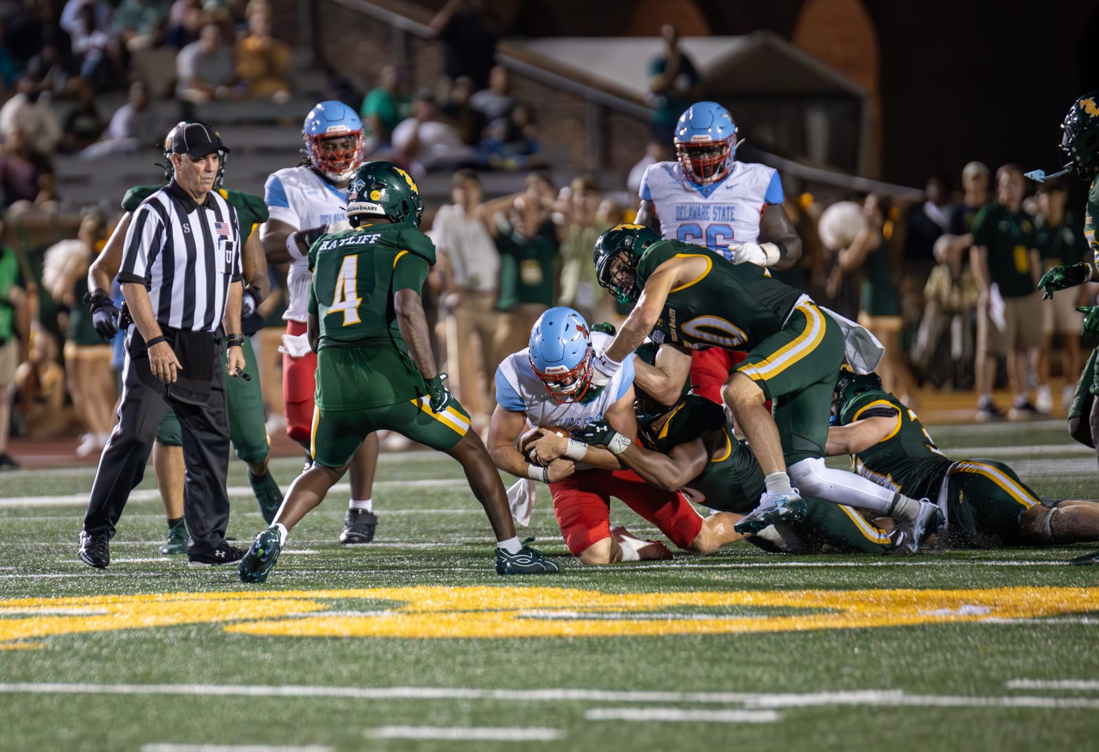 Jaden Ratliff and William & Mary defenders swarm a Delaware State ballcarrier at midfield