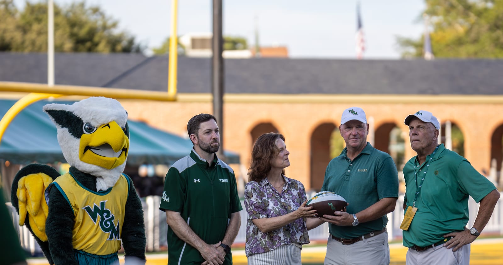 The Holtz family receives a commemorative football alongside the William & Mary mascot before kickoff