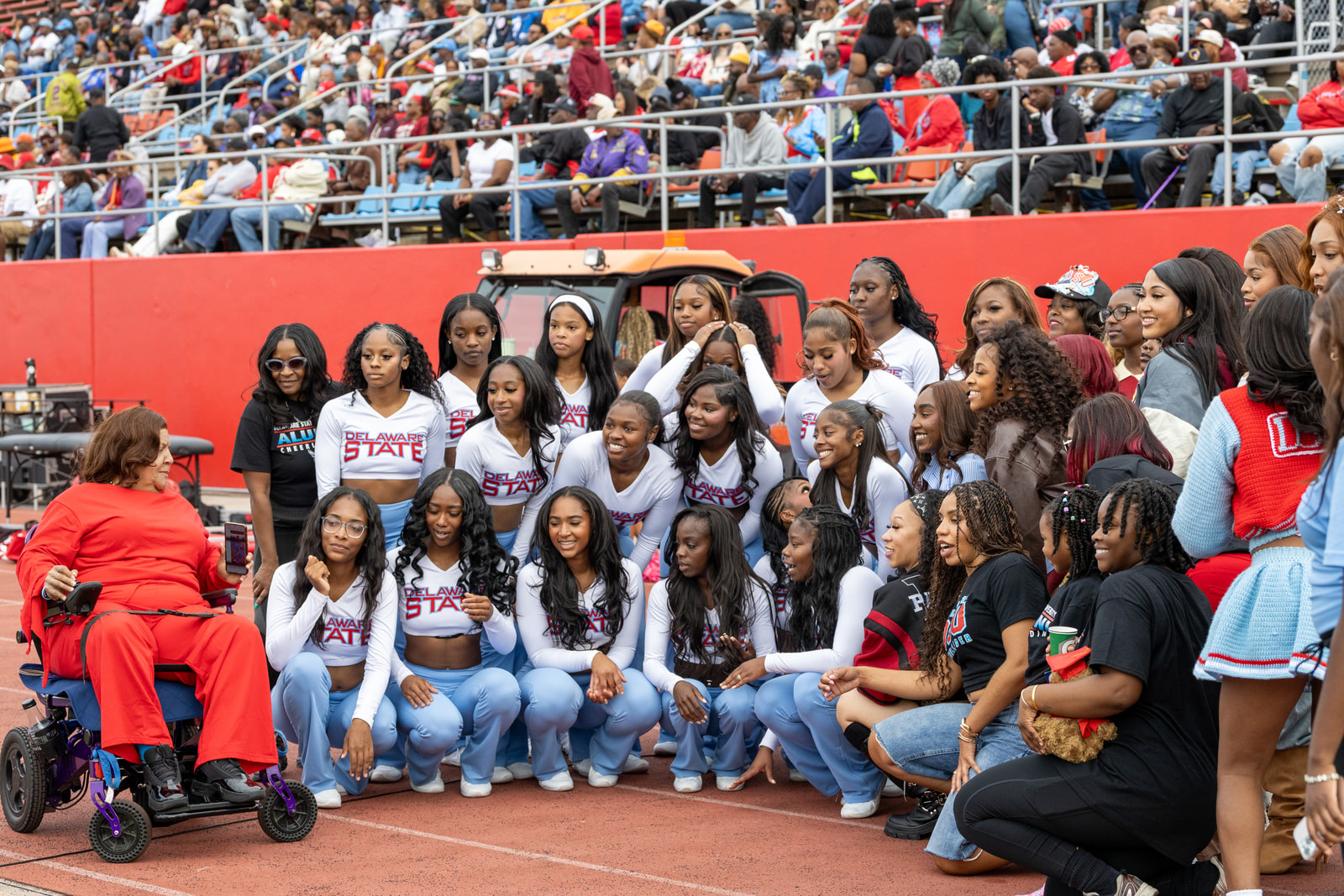 Delaware State cheerleaders gather for a group photograph in front of the stands at homecoming